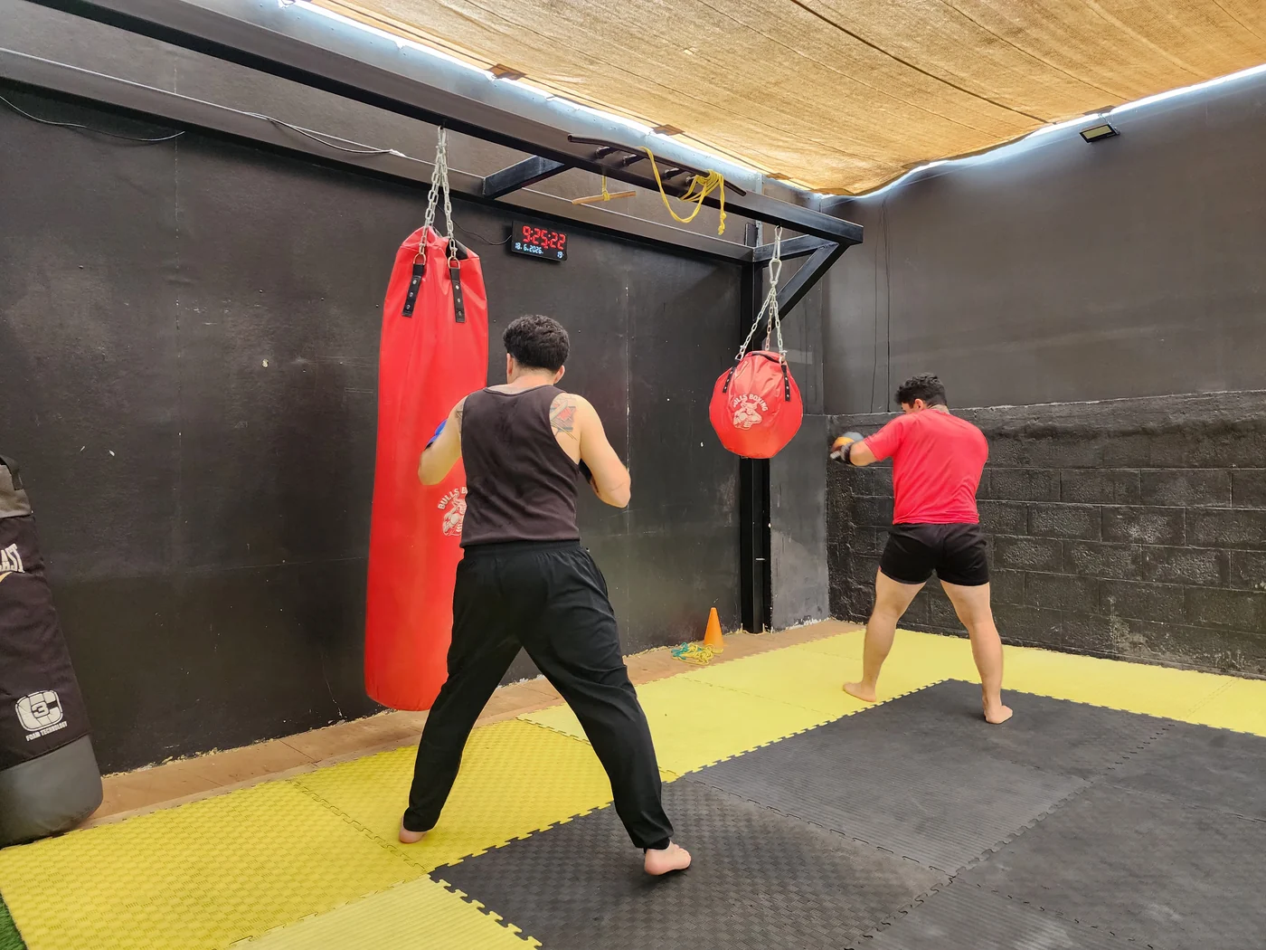Dos alumnos practicando con sacos en el Dojo Alkano